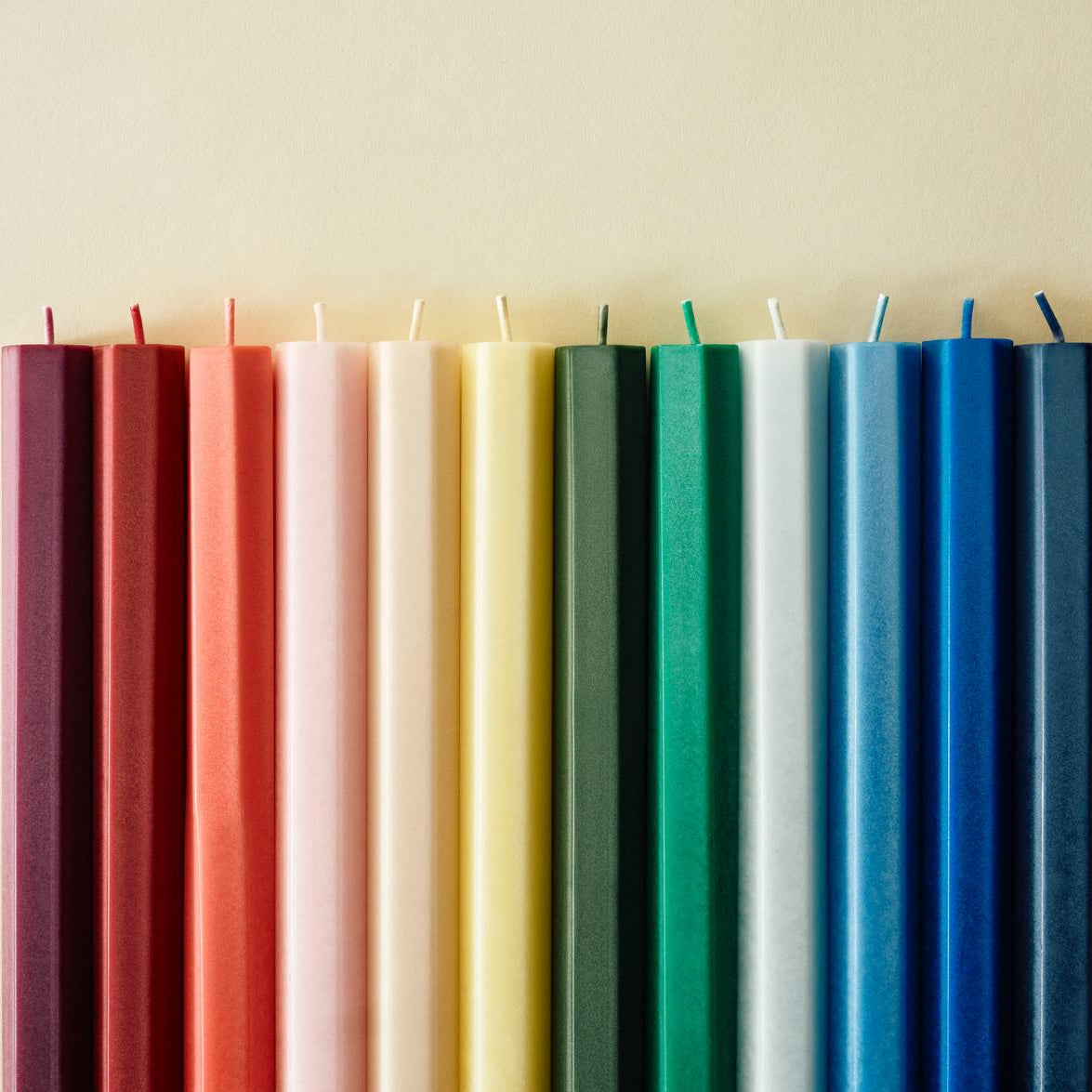 Row of colorful candles on a beige background