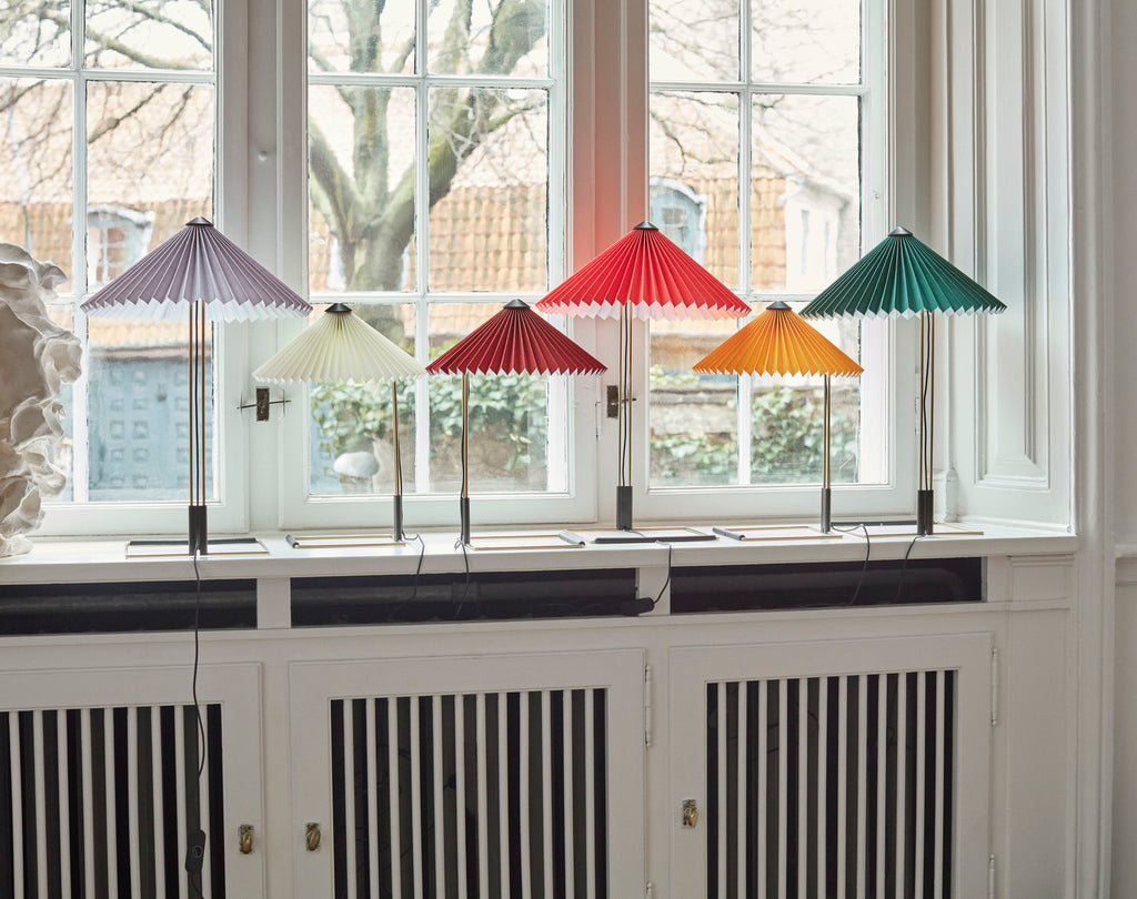 Colorful paper lamps on a radiator with a window in the background
