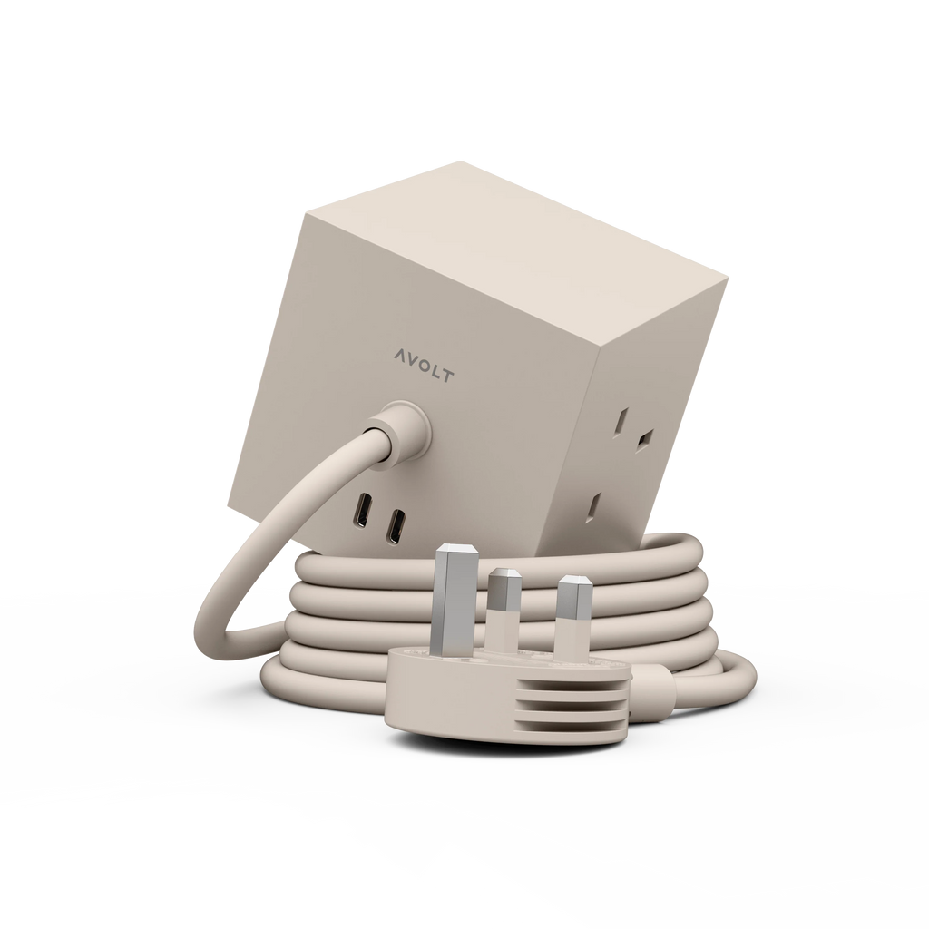 A beige AVOLT power adapter with a cube-shaped body, coiled cable, and UK three-pin plug, shown on a clean white background.