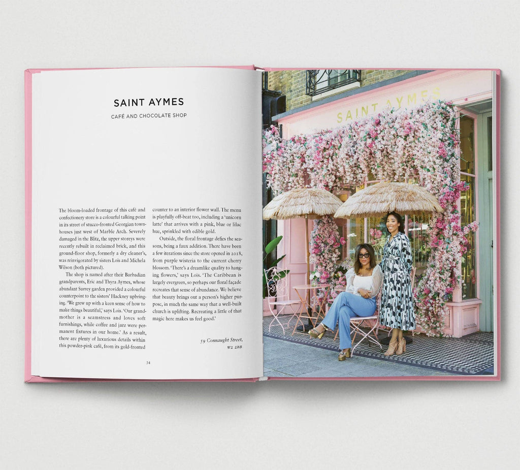 Open book showing a photo of two women in front of a pink building with floral decorations.