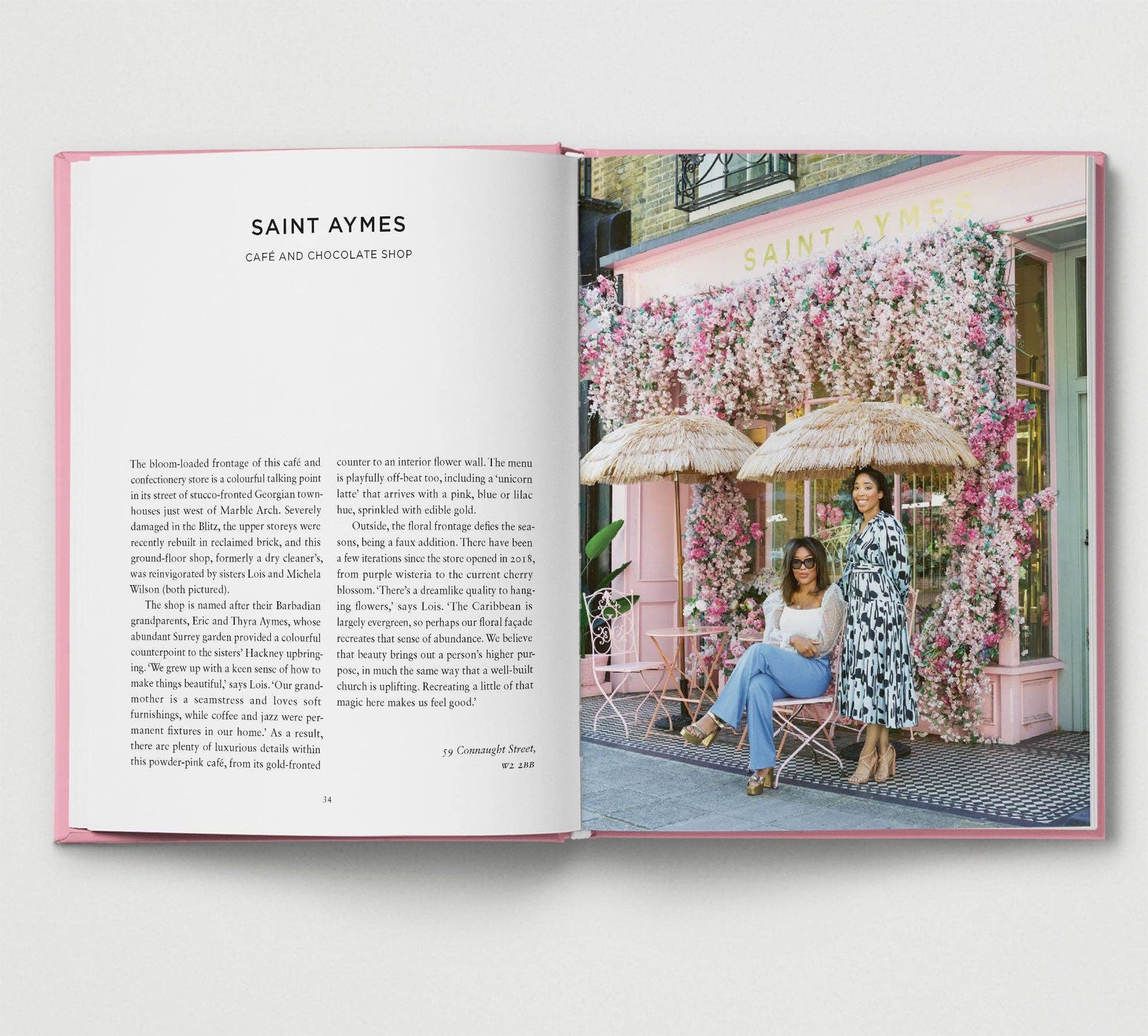 Open book showing a photo of two women in front of a pink building with floral decorations.