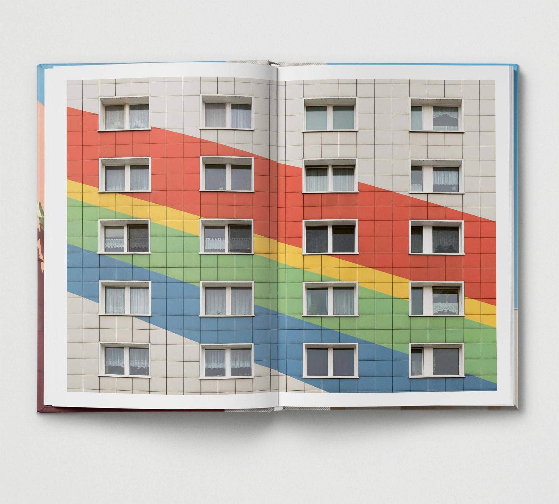 Open book showing a colorful building facade with rainbow pattern