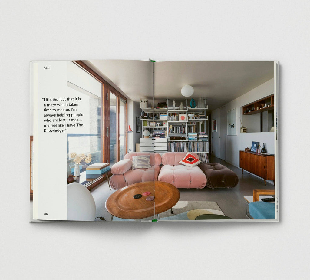 Open book showing a modern living room with pink sofa and wooden coffee table.