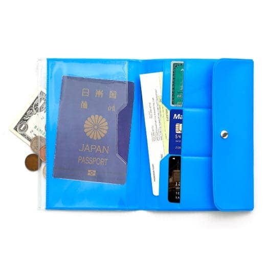 Blue travel organizer with Japanese passport, money, and other documents on a white background