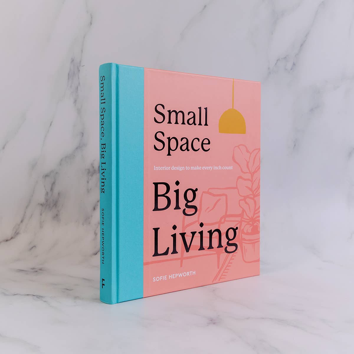 Book titled 'Small Space Big Living' on a marble surface