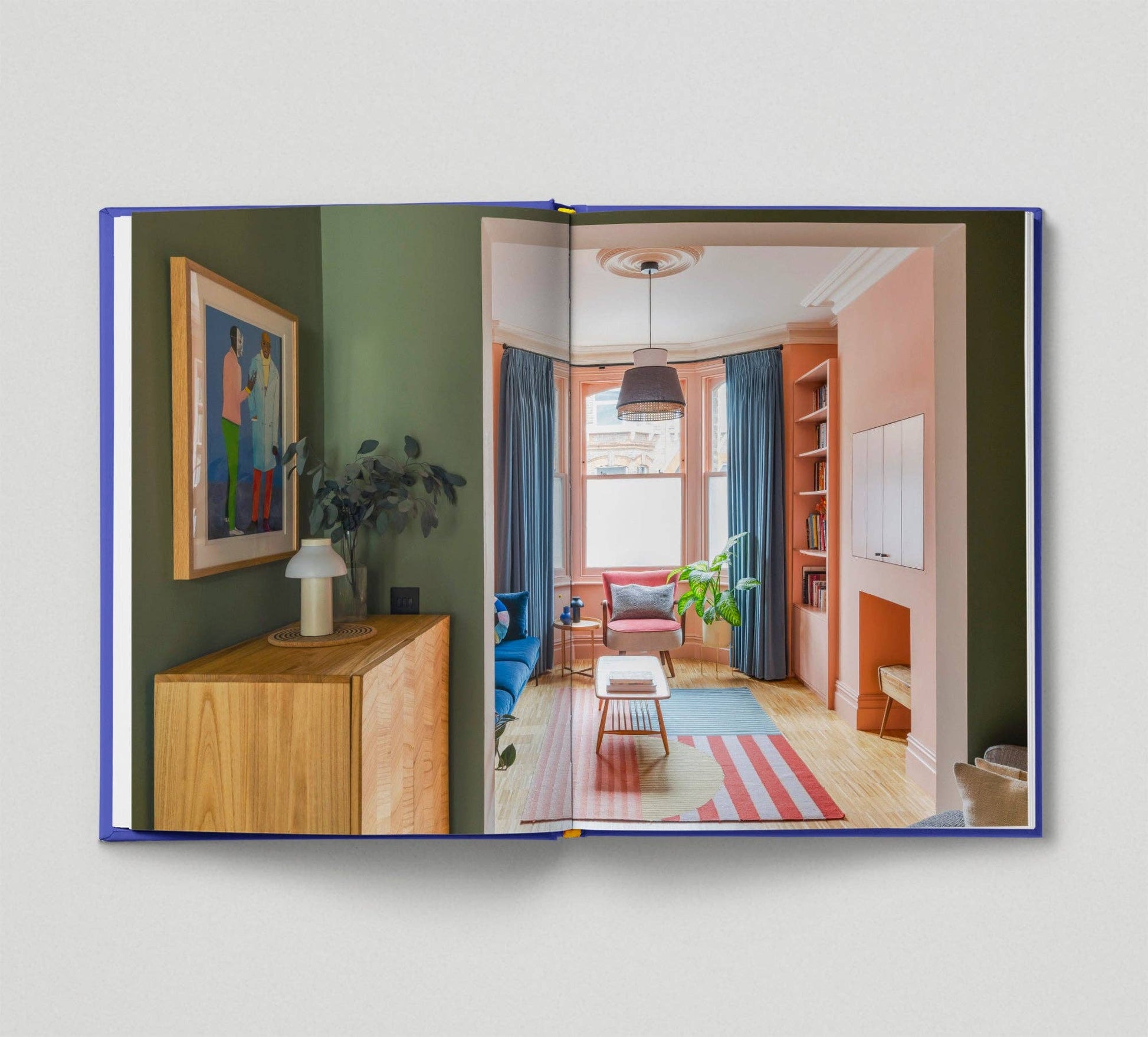 Open book showing a colorful interior design layout with furniture and decor.