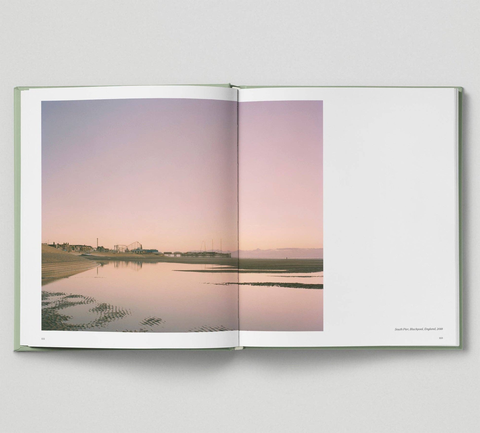 Open book showing a landscape with a lake and sky.