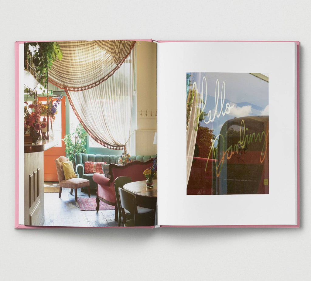 Open book showing interior design images with a 'hello darling' sign.