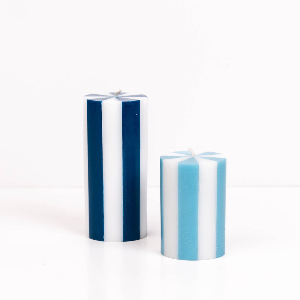 Two striped blue candles on a white background