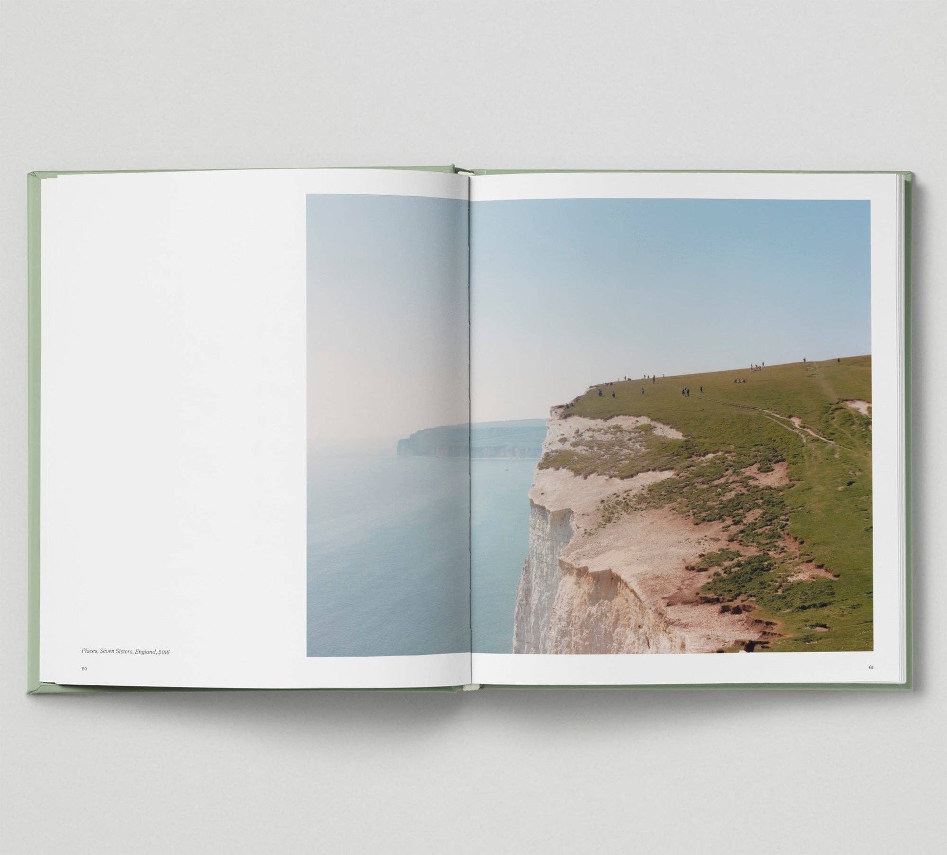 Open book showing a scenic view of a coastal landscape with cliffs and ocean.