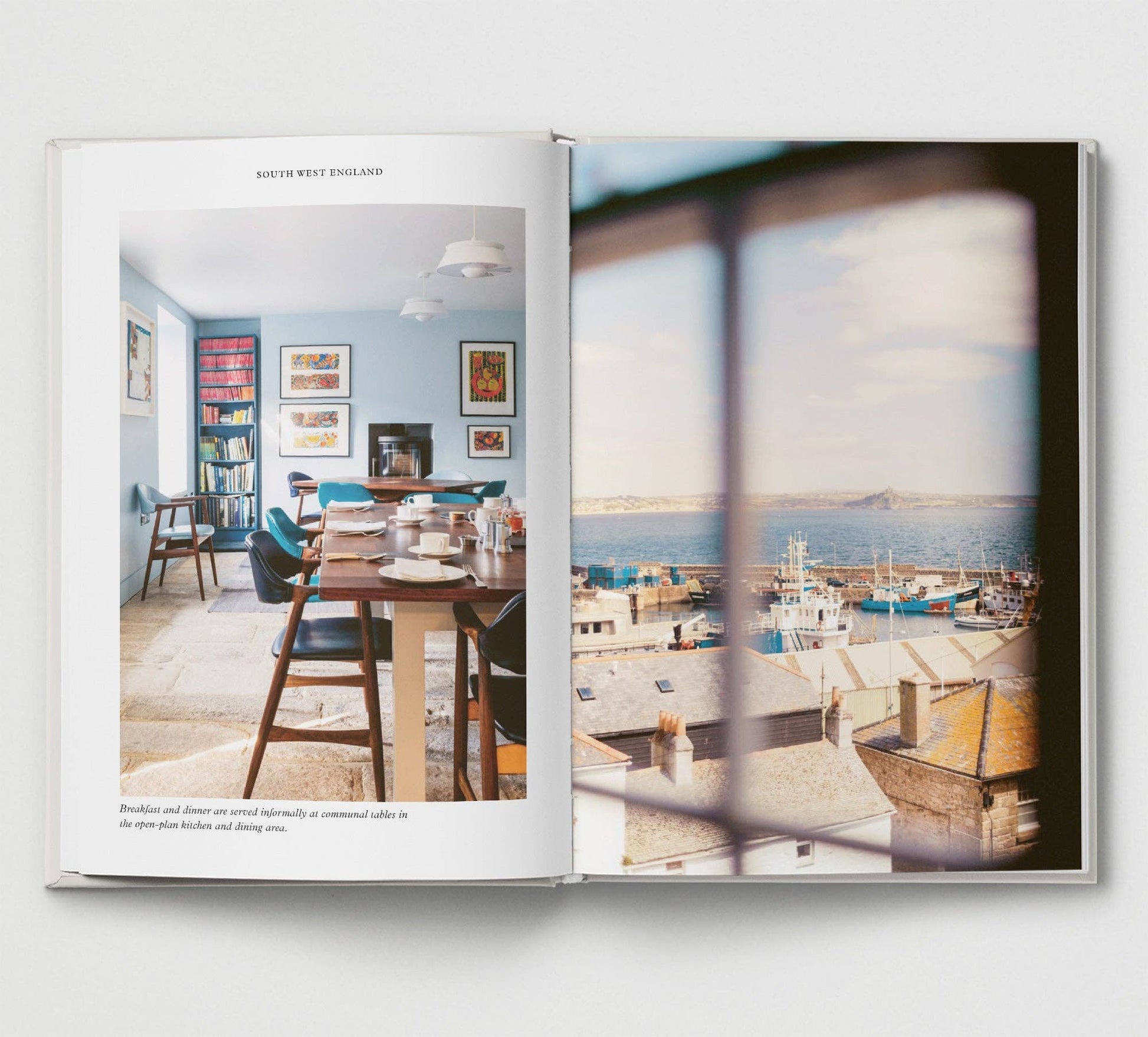 Open book showing a interior scene with a dining table and another with a harbor view.