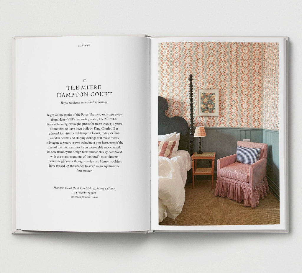Open book showing a bedroom interior with patterned wallpaper and pink armchair.